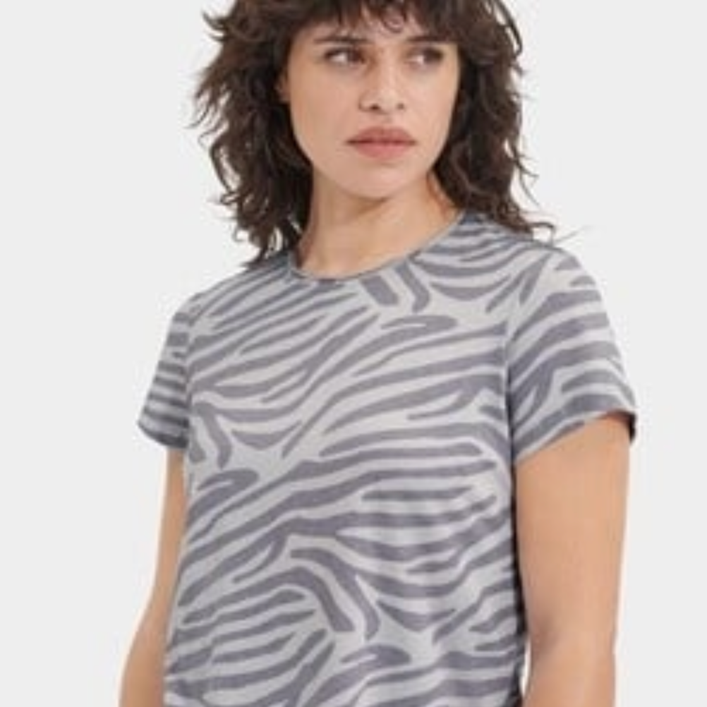 Person wearing a gray zebra pattern t-shirt on a white background. Available at be Charmed