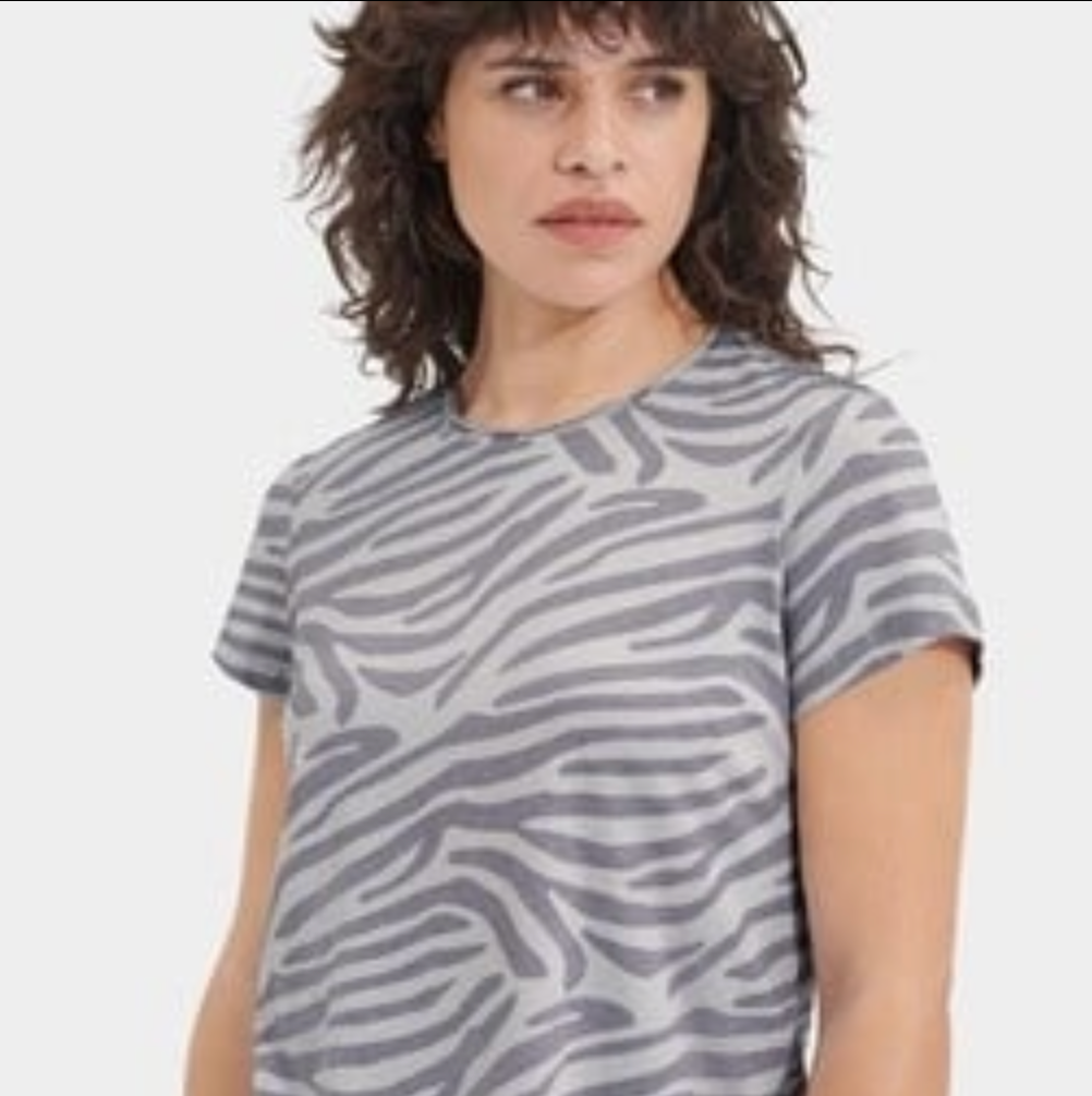 Person wearing a gray zebra pattern t-shirt on a white background. Available at be Charmed