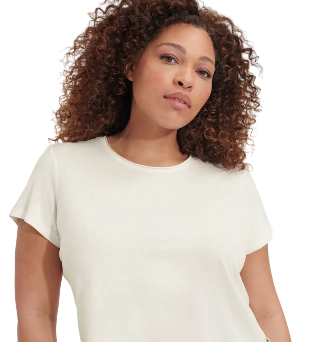 Woman wearing a white t-shirt against a plain background. Available at Be Charmed