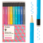 A 9-pack of Grabie medium point erasable gel pens in a classic gradient palette, shown in their clear plastic packaging alongside two loose pens demonstrating the blue erasable tip and the pencil lead texture. Available at Be Charmed