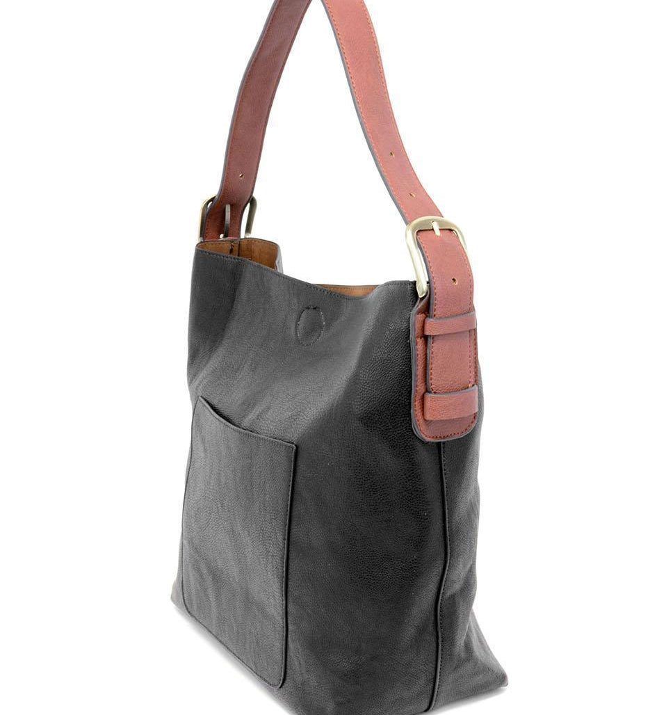 Black shoulder bag with brown strap on a white background. Available at Be Charmed