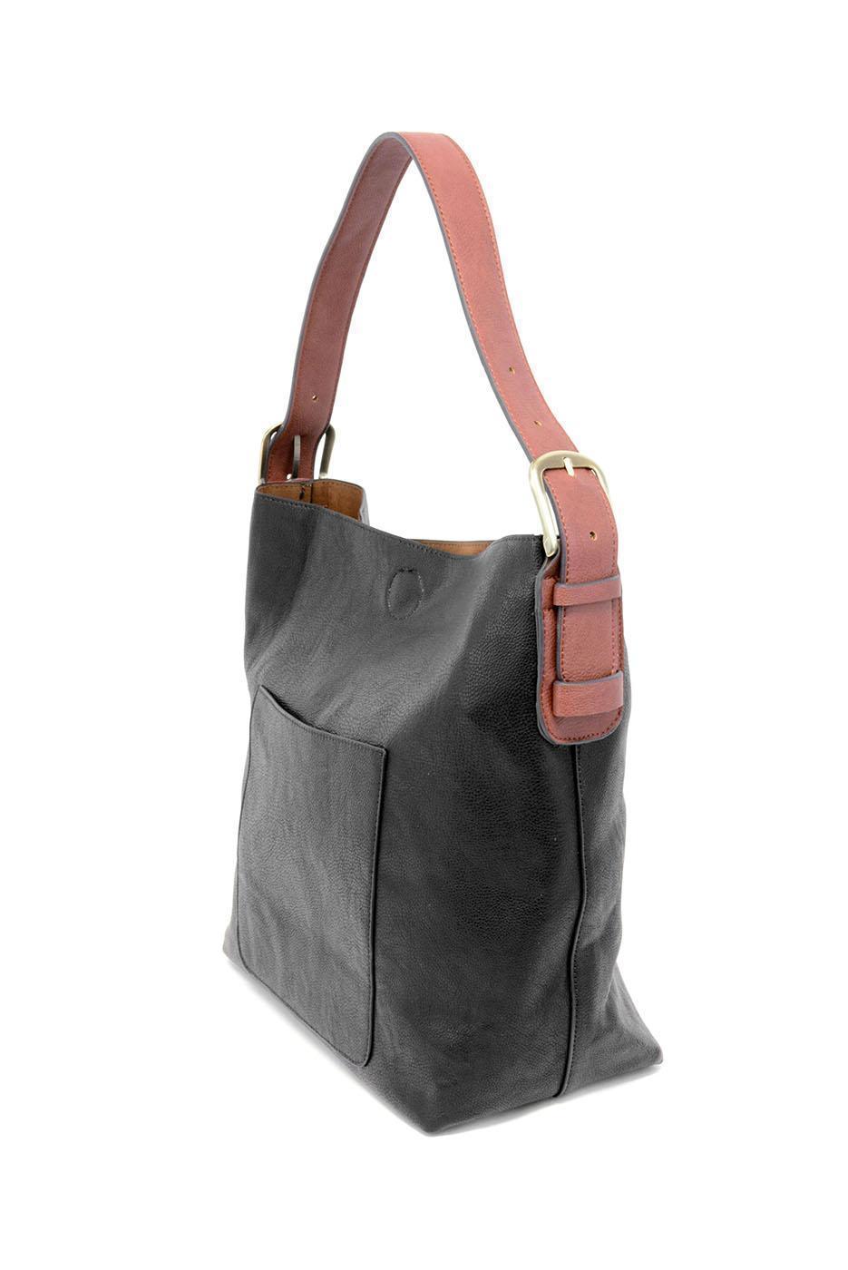 Black shoulder bag with brown strap on a white background. Available at Be Charmed