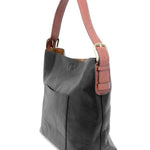 Black shoulder bag with brown strap on a white background. Available at Be Charmed
