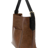 Brown leather tote bag with black handle on a white background. Available at Be Charmed