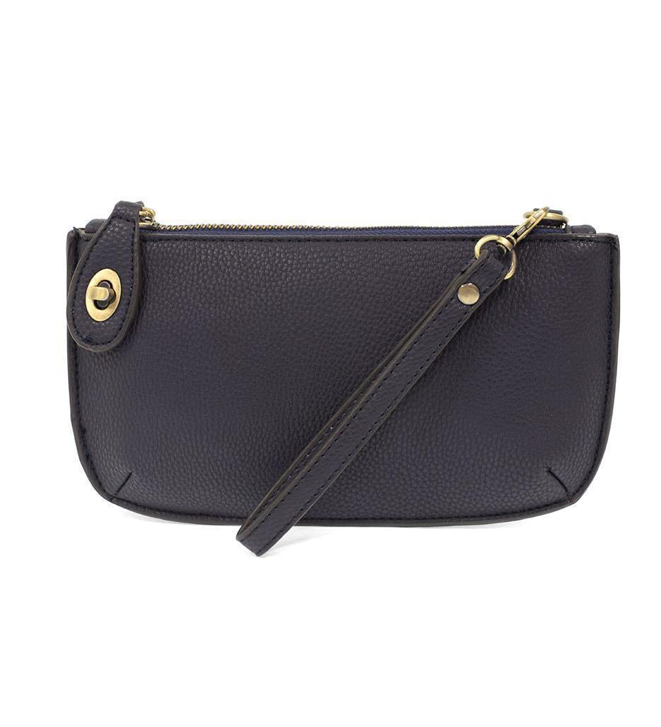 Joy Susan New Navy blue handbag with a strap on a white background. Available at Be Charmed