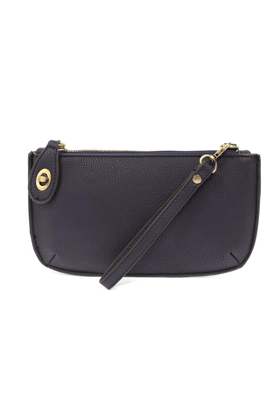 Joy Susan New Navy blue handbag with a strap on a white background. Available at Be Charmed