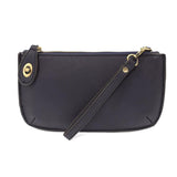 Joy Susan New Navy blue handbag with a strap on a white background. Available at Be Charmed
