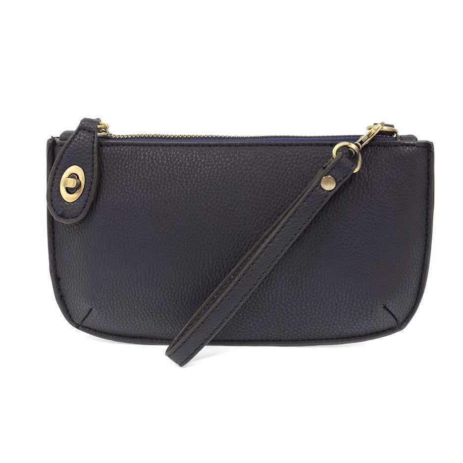 Joy Susan New Navy blue handbag with a strap on a white background. Available at Be Charmed