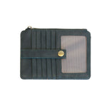 A Joy Susan castleton green card holder wallet with multiple card slots, a horizontal strap with a gold snap button, and a clear ID window on the right side, shown against a plain white background. Available at Be Charmed