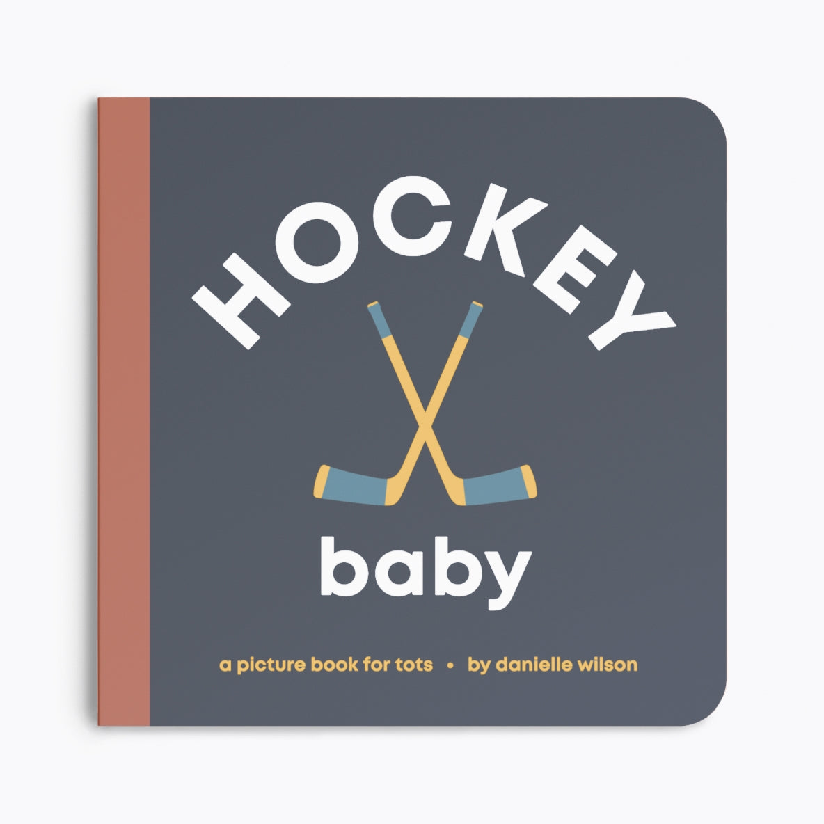 Book titled 'Hockey Baby' with hockey sticks on a dark blue background. Available at Be Charmed