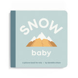 Book titled 'Snow Baby' with mountain illustration on a light blue background. Available at Be Charmed