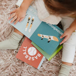 Child holding Left Hand Book House Snow Baby Board Book available at Be Charmed