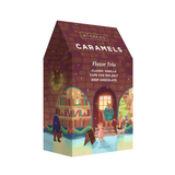 McCrea's Caramels Flavor Trio chocolate box with a whimsical winter library illustration on the front, featuring bear characters and holiday decorations. Available at Be Charmed