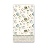 A rectangular holiday-themed hostess napkin, featuring a cream background with watercolor-style Christmas ornaments, snowflakes, stars, and a patterned border at the bottom. Available at Be Charmed