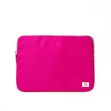 A bright pink Ori fabric laptop sleeve with a silver zipper and a small white brand label in the bottom right corner, shown against a plain white background. Available at Be Charmed