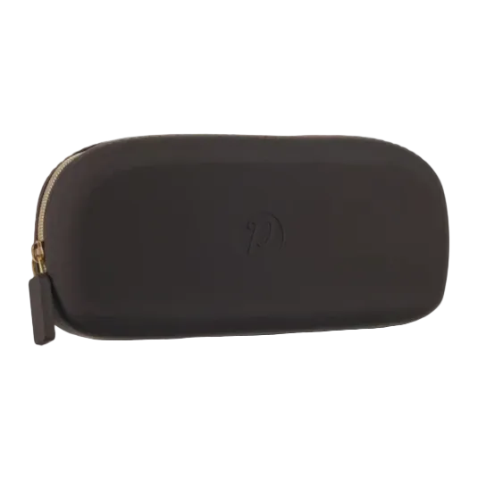 A dark brown soft-sided zippered pouch with a gold zipper pull and a debossed circular logo on the front, shown against a plain white background. Available at Be Charmed