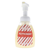 A bottle of Rinse Freshly Made Peppermint Foaming Hand Soap on a solid white background. The bottle is clear, showing the pale yellow liquid inside, and features a white pump dispenser with a red and white striped label. Available at Be Charmed
