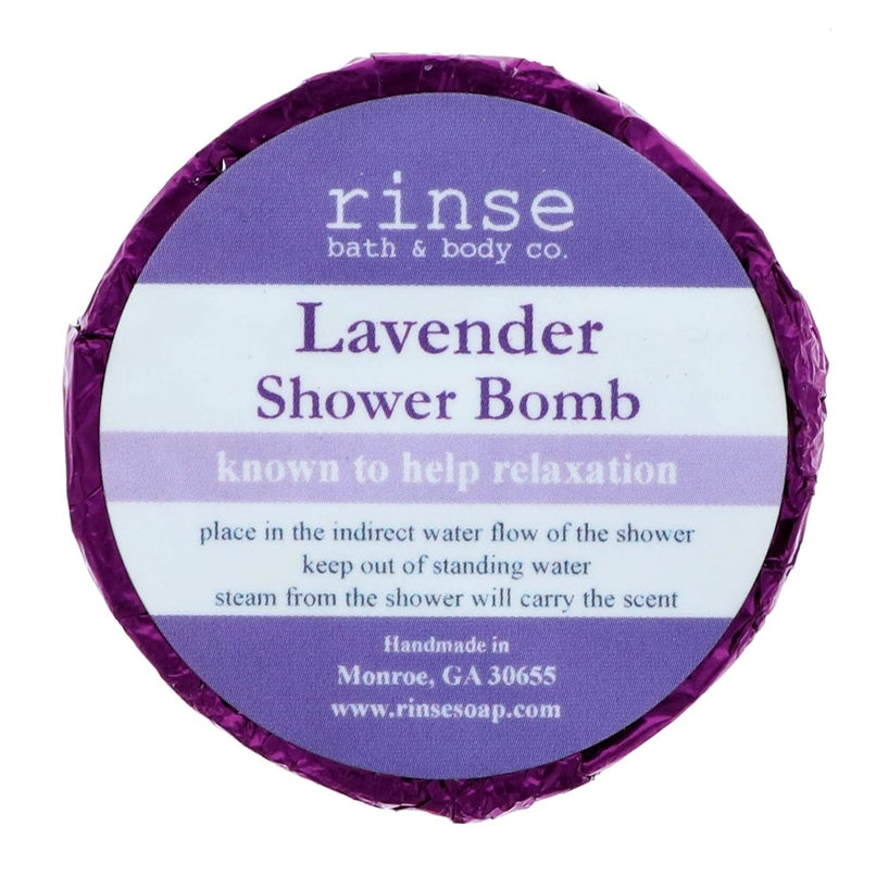 A circular blue shower bomb packaging with a label that reads 'Lavender Shower Bomb' from Rinse Bath & Body  Co. Available at Be Charmed