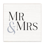 A Rustic Marlin square white wooden sign with a light natural wood border, featuring the text 'MR & MRS' in black serif font with a light gray ampersand. Available at Be Charmed