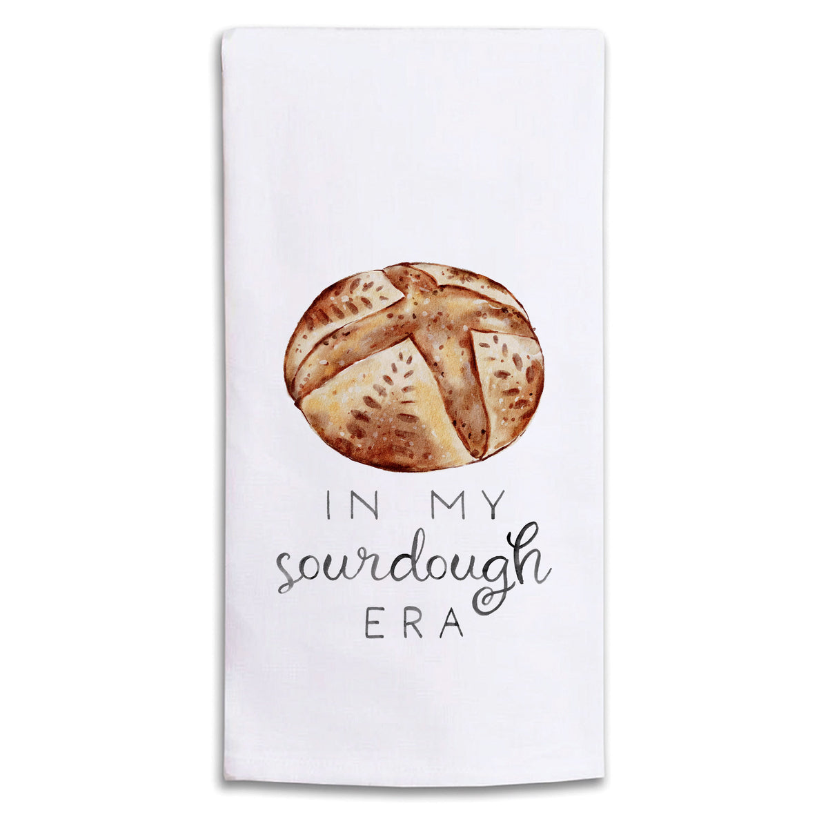 A Rustic Marlin white kitchen towel featuring a watercolor illustration of a round sourdough bread crust above the text 'IN MY sourdough ERA' in black lettering. Available at Be Charmed