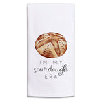 A Rustic Marlin white kitchen towel featuring a watercolor illustration of a round sourdough bread crust above the text 'IN MY sourdough ERA' in black lettering. Available at Be Charmed