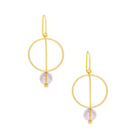 A pair of gold drop earrings with a minimalist circular design and a small light pink bead dangle. Available at Be Charmed