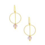 A pair of gold drop earrings with a minimalist circular design and a small light pink bead dangle. Available at Be Charmed