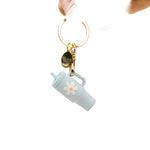 A aqua colored tumbler keychain with a flower detail on a white background, attached to a keyring. Available at Be Charmed