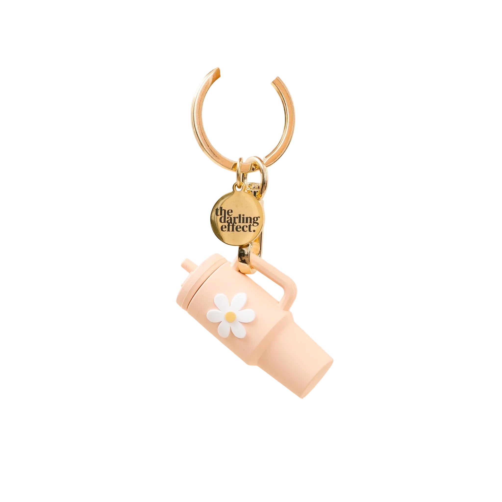 A blush colored tumbler keychain with a flower detail on a white background, attached to a keyring. Available at Be Charmed