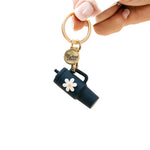 A navy colored tumbler keychain with a flower detail on a white background, attached to a keyring. Available at Be Charmed