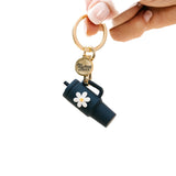 A navy colored tumbler keychain with a flower detail on a white background, attached to a keyring. Available at Be Charmed