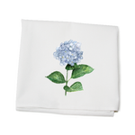 A white kitchen towel with a printed hydrangea flower design and green leaves on it, made of cotton. Available at Be Charmed