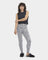 A woman standing, wearing high-waisted drawstring pants with a cloudy grey and white stripe pattern, paired with a black top and black footwear. Available at Be Charmed
