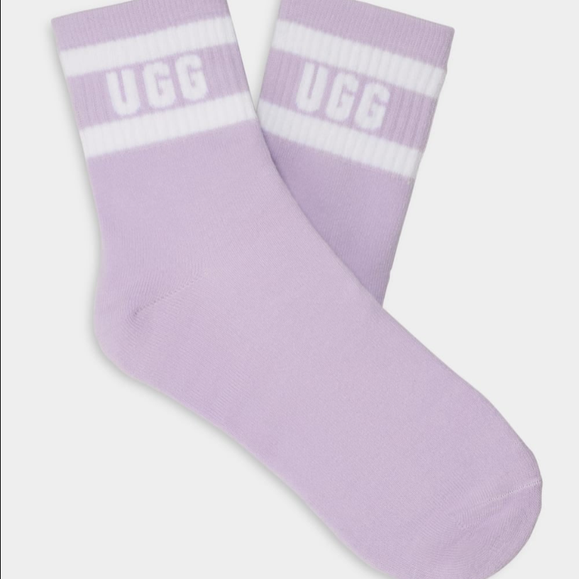 A pair of purple UGG women's socks with white stripes and the UGG logo on the ankle area. Available at Be Charmed