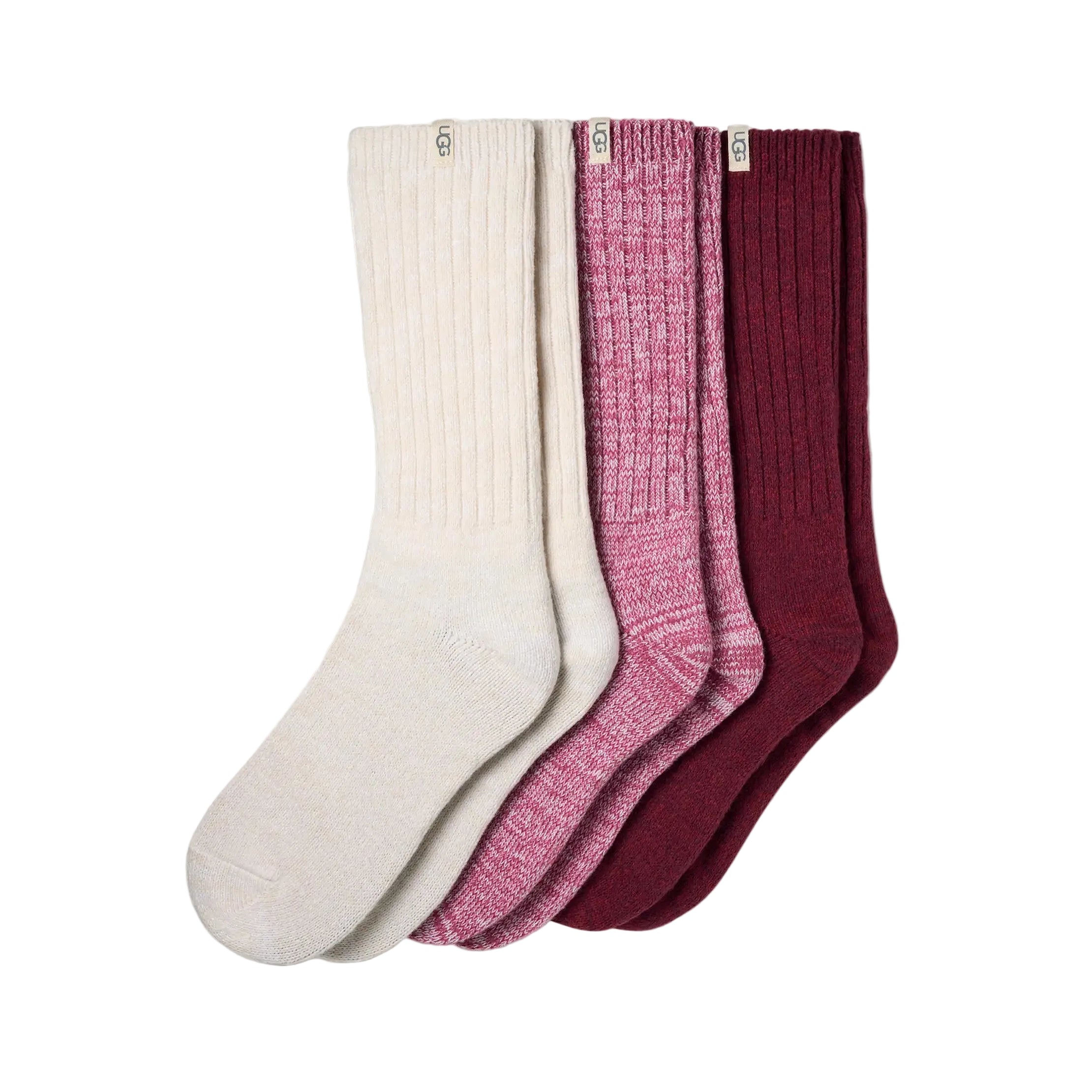 Three pairs of UGG ribbed crew socks in cream, heathered pink, and burgundy, arranged in a fan shape on a white background. Available at Be Charmed