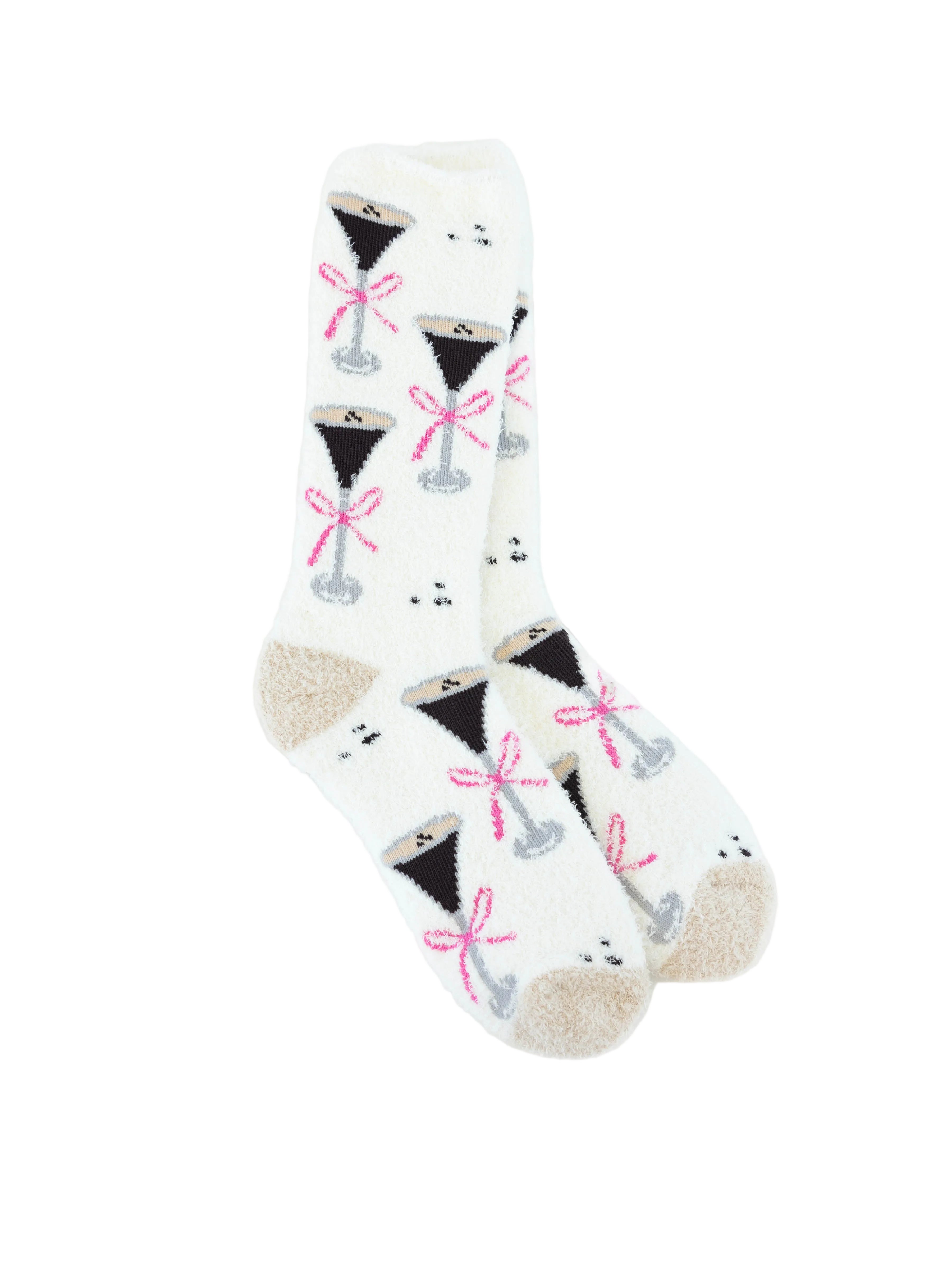 A pair of World's Softest white crew socks with a repeating pattern of black cocktail glasses tied with pink bows, featuring beige heels and toes, displayed on a clean white background. Available at Be Charmed