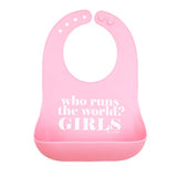 A light pink Bella Tunno silicone baby bib with a darker pink bottom pocket, featuring the white printed text 'who runs the world? GIRLS'. Available at Be Charmed