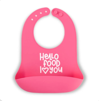 A bright pink Bella Tunno silicone baby bib with a white printed text design that reads 'Hello food I <heart> you' on a clean white background. Available at Be Charmed