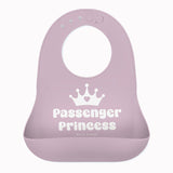 A light purple Bella Tunno silicone baby bib with a white crown graphic and the words 'Passenger Princess' printed on the front, set against a plain white background. Available at Be Charmed