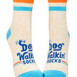 Blue Q Dog Walkin' ankle socks featuring a colorful illustrated graphic of dogs and owners, available at Be Charmed