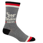 Blue Q Dog Walkin' men's crew socks featuring an illustrated graphic design of dogs and owners, available at Be Charmed