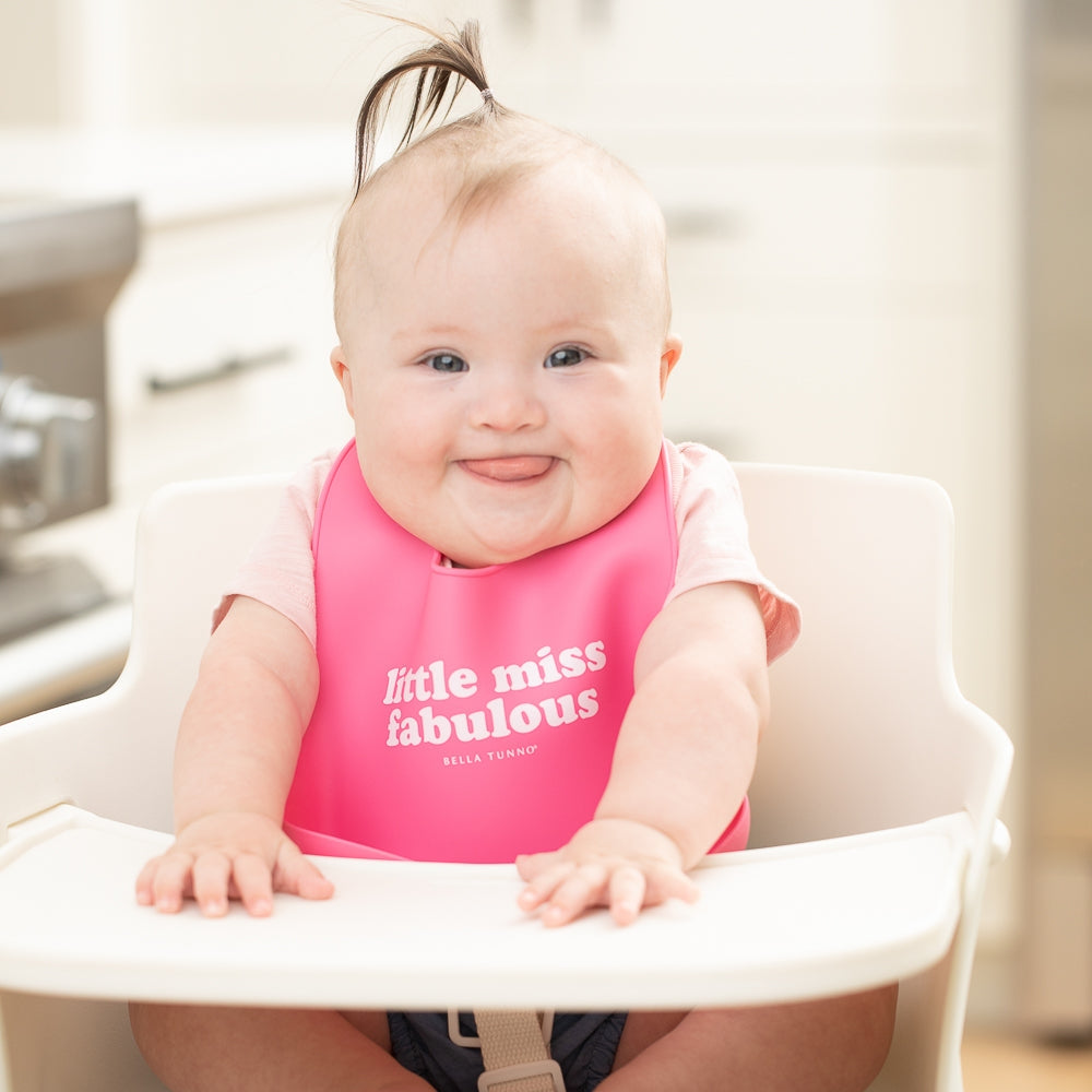 Bella Tunno Little Miss Fabulous Wonder Bib on smiling baby in highchair 