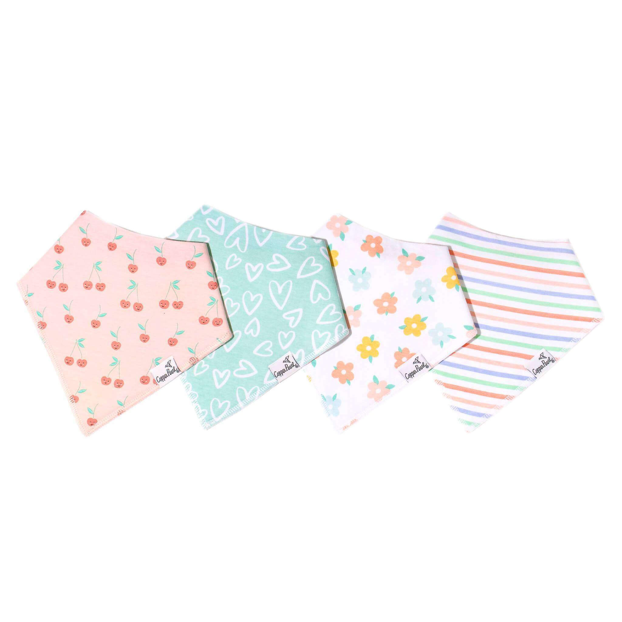 Four colorful baby bibs with different patterns on a white background. Available at Be Charmed