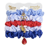 Set of scrunchies with charms on a branded card, featuring blue, red, and white colors. Available at Be Charmed