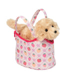 Small plush dog inside a pink bag with strawberry pattern on a white background. Available at Be Charmed