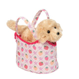 Small plush dog inside a pink bag with strawberry pattern on a white background. Available at Be Charmed