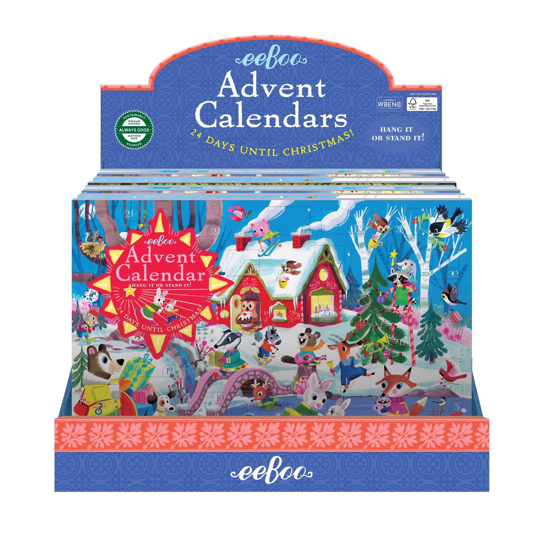 Packaging for eeBoo Advent Calendars featuring a colorful illustration of a snowy scene with people, houses, and a Christmas tree. Availlable at Be Charmed