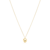 Gold necklace with a round pendant on a white background. Available at Be Charmed
