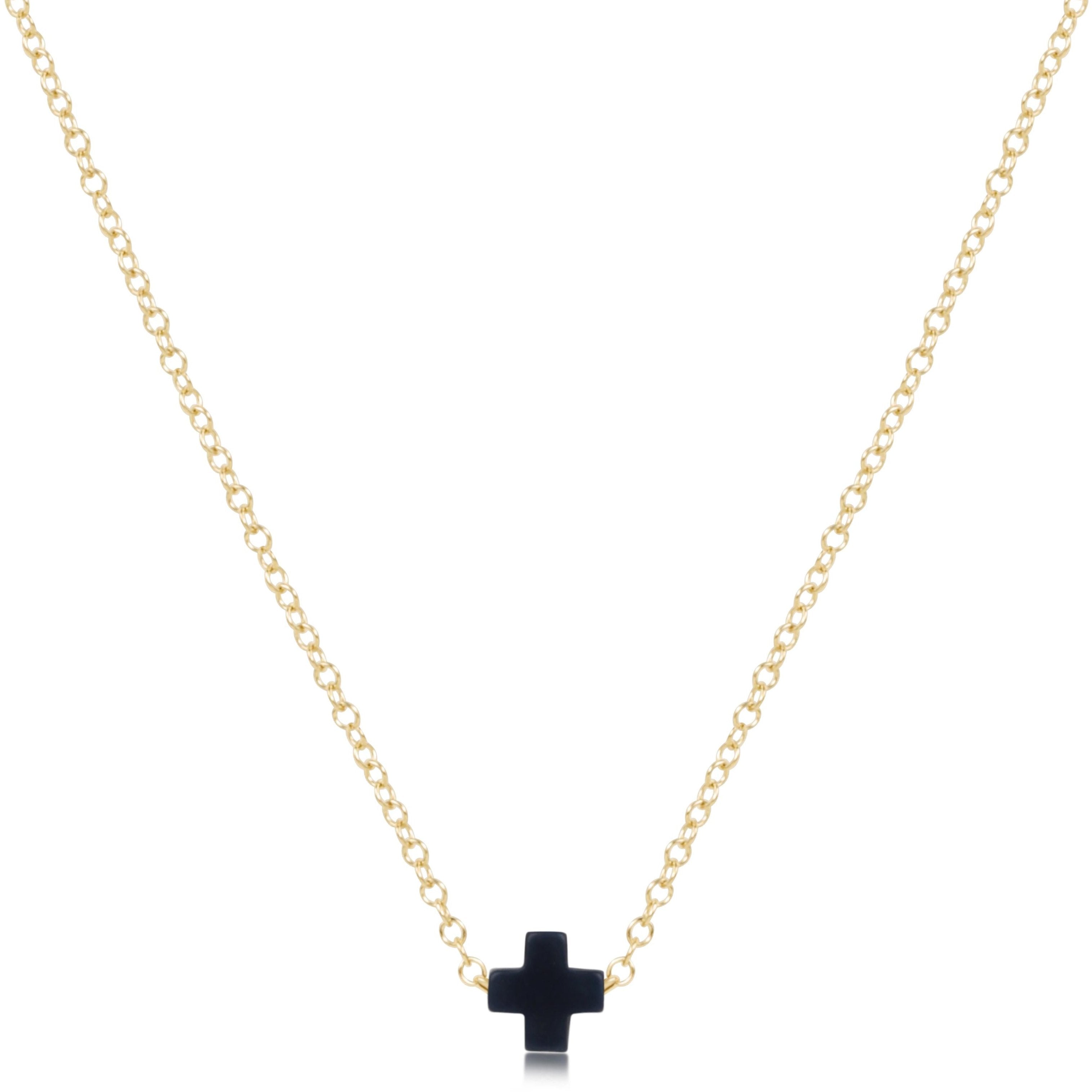 enewton Gold necklace with a navy cross pendant on a white background. Available at Be Charmed