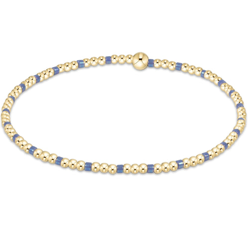 A bracelet with bright blue and gold-colored 2mm seed beads, featuring gold-filled beads. Available at Be Charmed